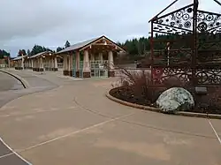 An empty bus station with three shelters, pieces of public artwork, and a large paved area