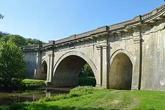 The Dundas Aqueduct in Bath Stone by the civil engineer John Rennie carrying the Kennet and Avon Canal over the River Avon and the Wessex Main Line railway at Limpley Stoke, near Bath, England