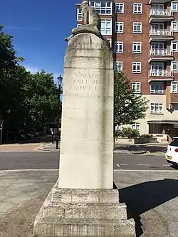 East face of memorial. Inscription reads "One King, One Empire, Empire Day". Trees of Kensington Gardens visible on the left