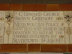 A tablet formed of five tiles of varying sizes, bordered by yellow and blue flowers in an art nouveau style
