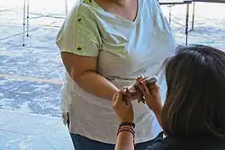 A person receives electoral ink on her thumb after casting her vote.