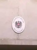 Plaque outside the embassy in German depicting the coat of arms of Austria