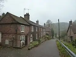 A row of brick terraced cottages (left), a detached house below and to the right