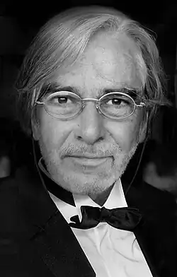 Caucasian male with oval spectacles, 60s, in black tie