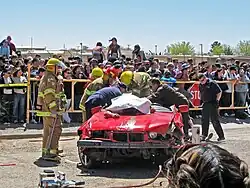 Emergency responders rescuing victims at a simulated car crash scene.