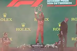 Leclerc lifting his trophy on the podium after winning the 2022 Austrian Grand Prix