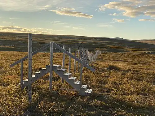 Fence with stairs and ATV gate along the Finland–Norway border in Siđusgohpi between Käsivarsi Wilderness Area and Reisa National Park. Reindeer are prevented from crossing the border, while humans can cross freely.