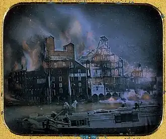 Hand-tinted daguerrotype of the Fire at the Ames and Dolittle Mills, 1853, considered one of the first news photographs.