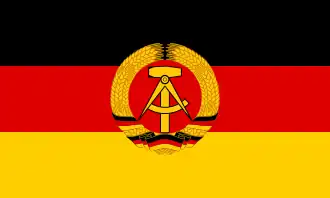The flag of East Germany, defaced with a national emblem