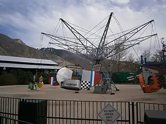 A historic spinning amusement ride with ride vehicles that vaguely resemble painted fighter aircraft