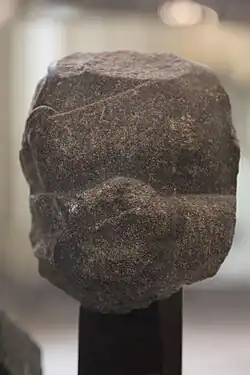 Fragment of the statue of a devotee, with inscription in the name of Naram-Sin: "To the god Erra, for the life of Naram-Sin, the powerful, his companion, the king of the four regions, Shu'astakkal, the scribe, the majordomo, has dedicated his statue".[122]