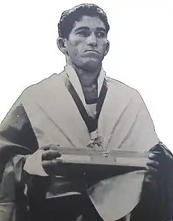 A man draped in the Colombian flag with a gold medal around his neck