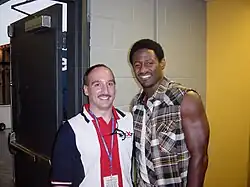 Mitchell posing with a radio station staff member backstage at a country music concert.