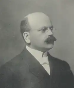 Black-and-white headshot of Hinitt facing right