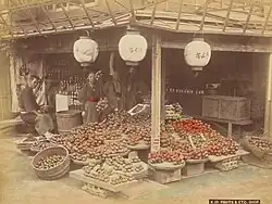 A hand-colored silver albumen print of a fruit market in Japan taken by Kusakabe Kimbei