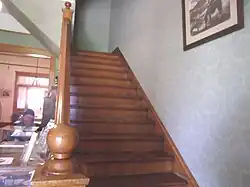 Staircase leading to the second floor of the Manistee Mansion .