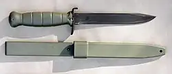 Glock field knife/bayonet and its scabbard. The upper crossguard is bent forward and can be used as a bottle opener.