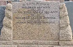 a colour photograph of a brown granite or marble headstone