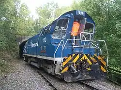 Diesel shunting locomotive in blue livery, displaced at an angle across the railway tracks, with damage visible at the rear