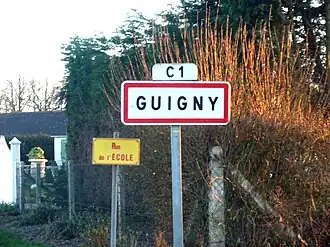 A road sign at the entry to Guigny
