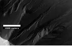 Gullies in Ross Crater, as seen by HiRISE under the HiWish program. Because the gullies are on the narrow rim of a crater and they start at different heights, this example is not consistent with the model of gullies being caused by aquifers.