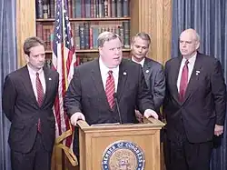 Four suits before a microphone.