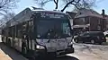 A city bus pulling up to a bus stop.