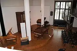 Event space for concerts, featuring a salon organ and a double grand piano.