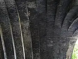 View of the intrados of the arch, looking upwards. The blue engineering bricks are stained white in part by minerals leached from the mortar, but in general the brickwork is in good condition.
