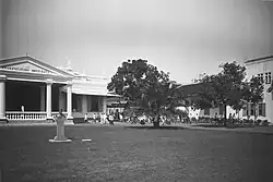 A black-and-white picture of a courtyard with white buildings