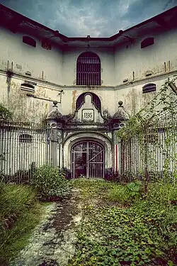 Area surrounded by walls, barred windows, and a gate