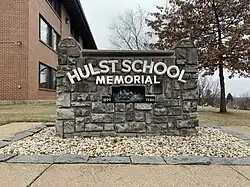 A stone memorial that reads "Hulst School Memorial 1899 1949"