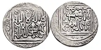 A photograph of the two sides of a coin with a white background. The coins are grey-black in color and have white-colored Perso-Arabic calligraphy on them