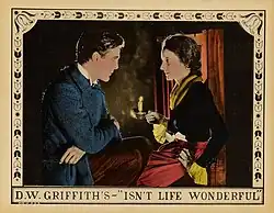 Lobby card featuring two people in period clothing