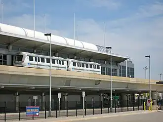 An AirTrain vehicle stopped outside the Lefferts Boulevard station, an elevated stop