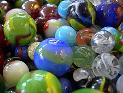 multiple toy marbles of various sizes, colors, and designs