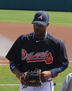Jason Heyward on a grassy field, wearing a Braves uniform and holding a baseball glove