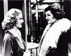 Gray-scale film still of Harlow and Loy facing each other