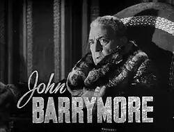 Publicity shot of a noticeably older, heavier Barrymore, wearing a fur coat; side on, facing slightly to his left