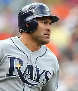 baseball player in a grey uniform that says "RAYS" in navy letters across the front