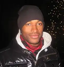 A man is wearing a coat and a beanie.