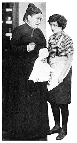 Black and white film still showing two women in 1917 period dress