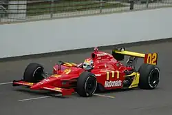 Photograph of Wilson driving a red Dallara-Honda car on a race track