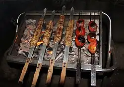 Kabab koobideh and tomato grilling over barbecue grill
