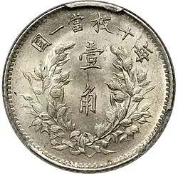 Silver coin featuring Chinese text surrounded by a wreath
