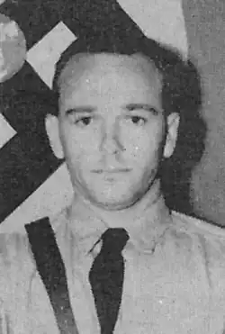 Black and white photo of Allen wearing a Nazi uniform with a Nazi flag behind him