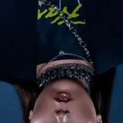 An upside-down shot of Kenya Grace with chains around her neck