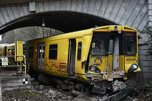 An image of the 2021 train crash, after having crashed through the passenger walkway, with damage to its front