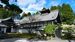 A wooden building with white walls and large gabled roof.