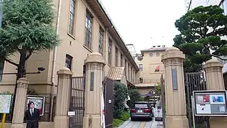 Concrete-pillared gateway next to three-story concrete building